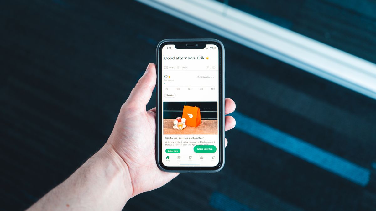 Hand holding a phone with a delivery app